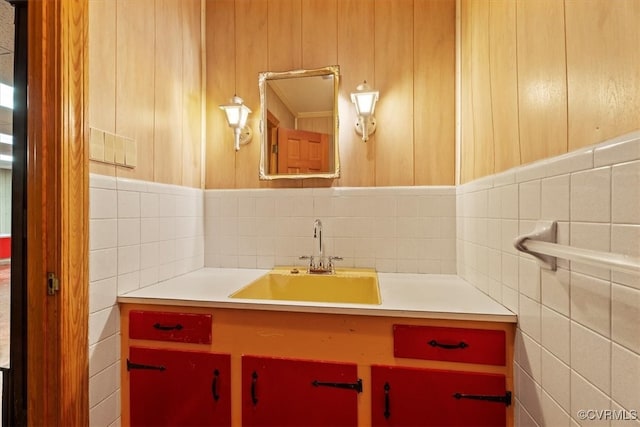 bathroom with vanity and tile walls