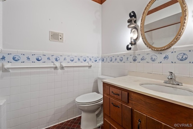 bathroom featuring a wainscoted wall, vanity, toilet, and tile walls