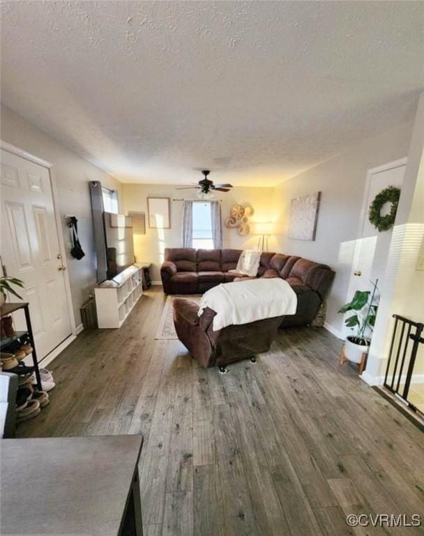 bedroom featuring a textured ceiling, dark wood-type flooring, and ceiling fan