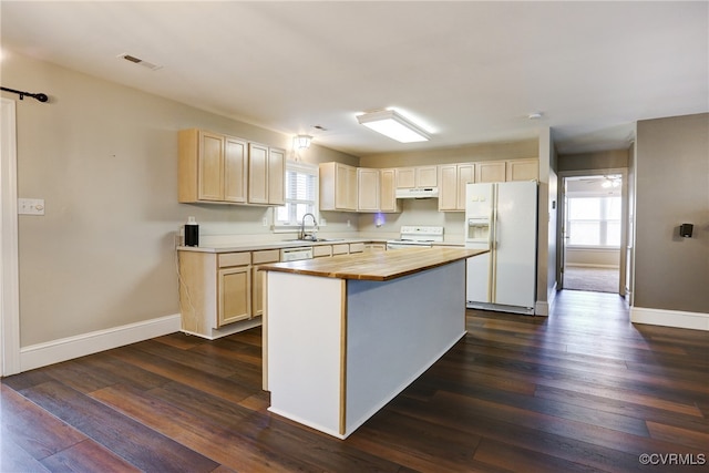 kitchen with dark wood-style floors, a center island, a sink, white appliances, and under cabinet range hood