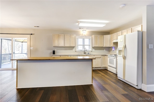 kitchen featuring white appliances, dark wood-type flooring, a sink, and a center island