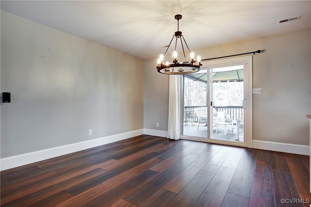 empty room with an inviting chandelier, baseboards, visible vents, and dark wood-type flooring