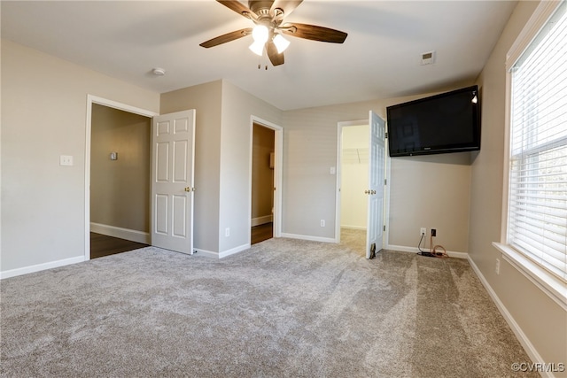 unfurnished bedroom featuring a ceiling fan, carpet, visible vents, and baseboards