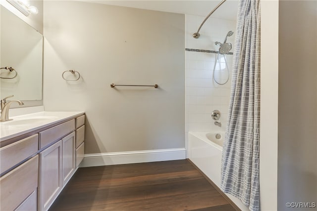 bathroom featuring shower / bath combo, vanity, baseboards, and wood finished floors