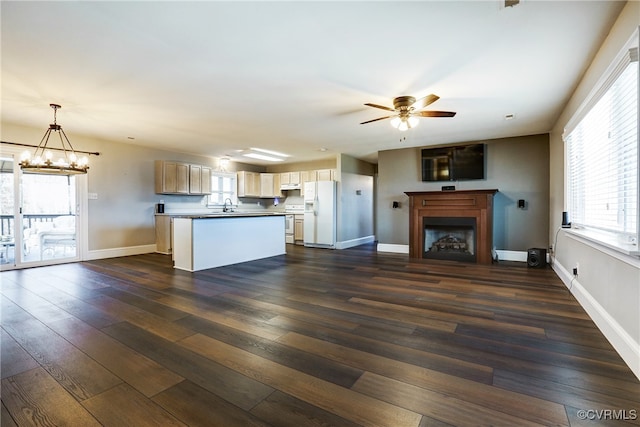 kitchen featuring dark countertops, open floor plan, stove, and white refrigerator with ice dispenser