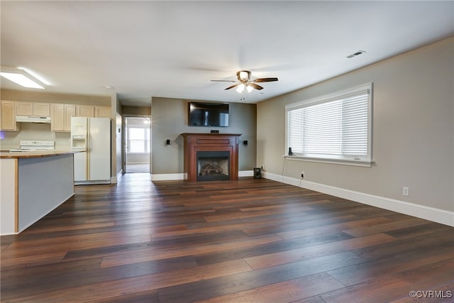 unfurnished living room featuring baseboards, a fireplace, visible vents, and dark wood-style flooring