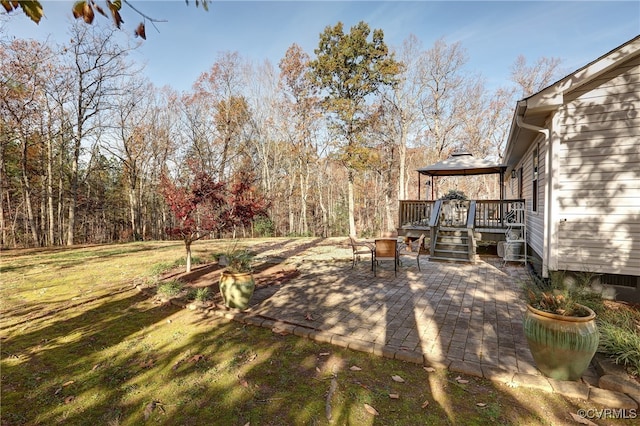 view of yard featuring a patio, a wooden deck, and a gazebo