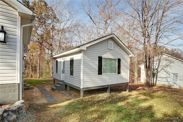 view of property exterior featuring entry steps and a yard