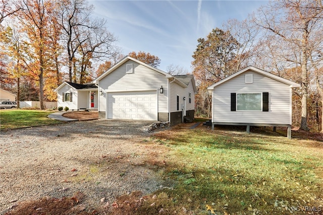 exterior space featuring an attached garage, a lawn, and gravel driveway