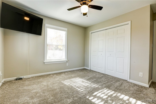 unfurnished bedroom with carpet floors, a closet, ceiling fan, and baseboards