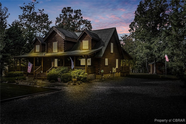 log-style house featuring covered porch