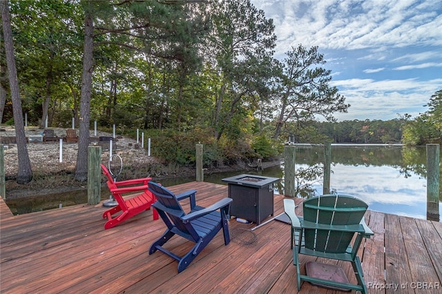 wooden deck with a water view and a fire pit