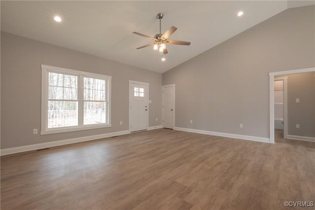 unfurnished living room with ceiling fan, wood-type flooring, and high vaulted ceiling