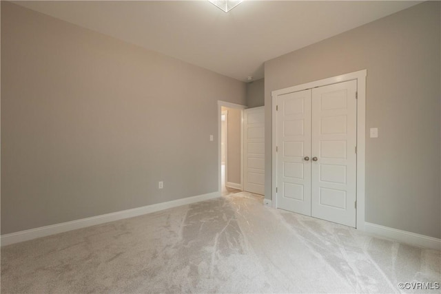 unfurnished bedroom featuring light carpet and a closet