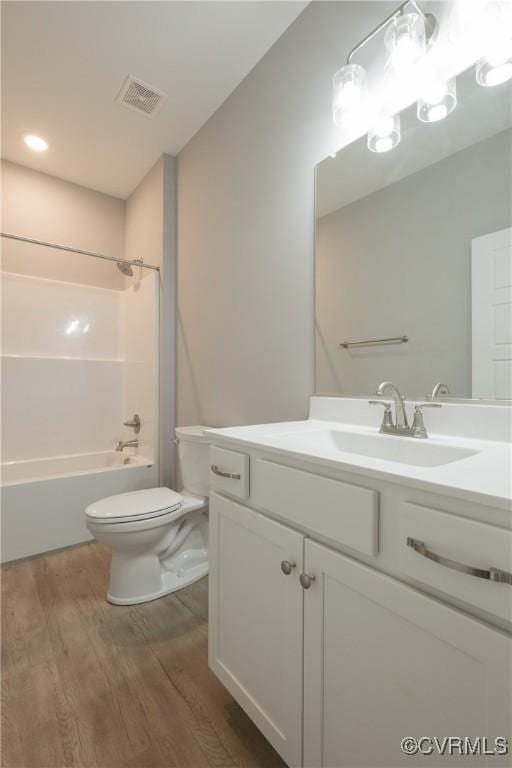 full bathroom featuring vanity, toilet,  shower combination, and hardwood / wood-style floors