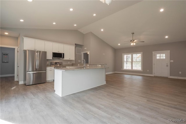 kitchen featuring white cabinetry, light stone countertops, a kitchen island with sink, and stainless steel appliances