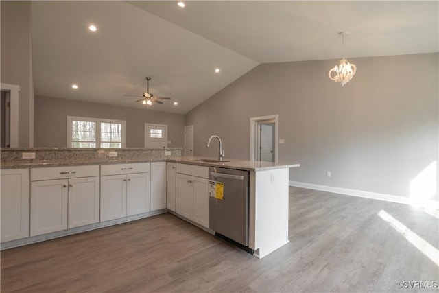 kitchen featuring sink, white cabinets, stainless steel dishwasher, light stone counters, and light wood-type flooring