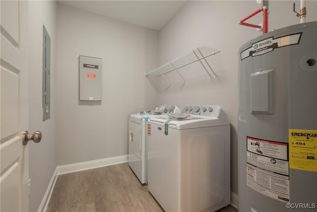 washroom featuring washer and dryer, electric water heater, and light hardwood / wood-style flooring