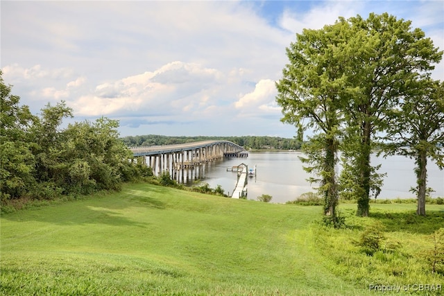 dock area featuring a water view and a lawn