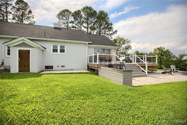 rear view of property with a yard, a patio, and a deck