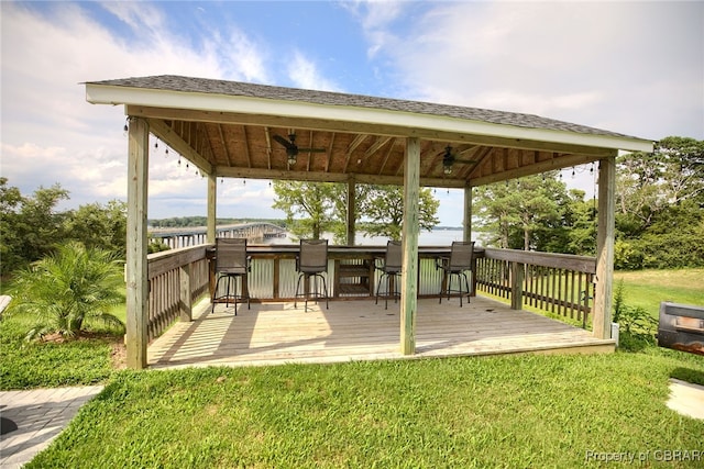 deck featuring a gazebo, a yard, an outdoor bar, and ceiling fan