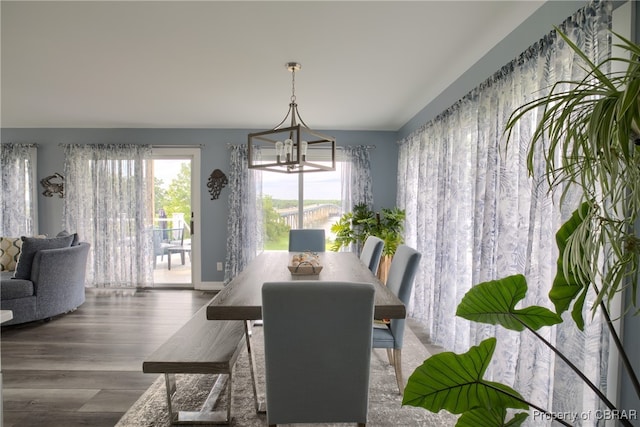 dining area with hardwood / wood-style flooring and a notable chandelier