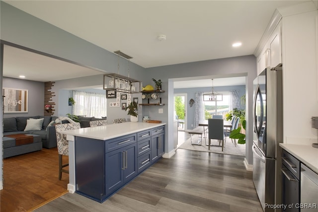 kitchen with blue cabinetry, stainless steel fridge, dark hardwood / wood-style floors, and white cabinetry