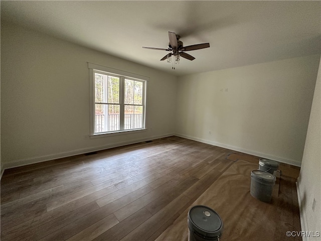 empty room with dark hardwood / wood-style floors and ceiling fan