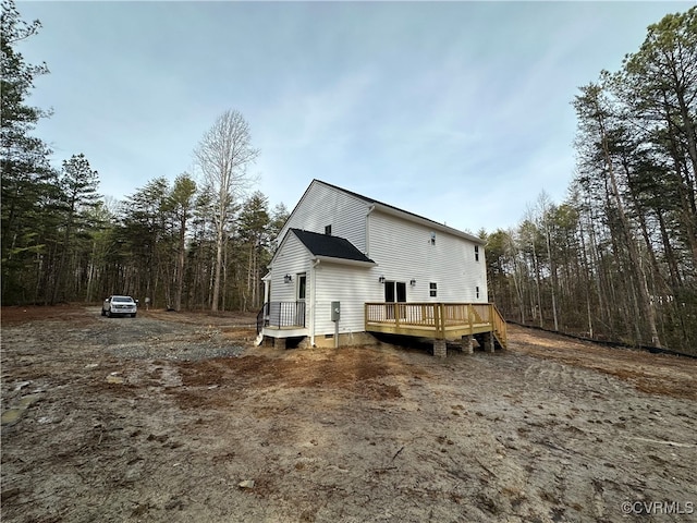 rear view of property featuring a wooden deck