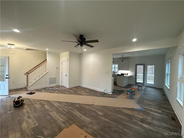 unfurnished living room with dark wood-type flooring, stairway, visible vents, and recessed lighting