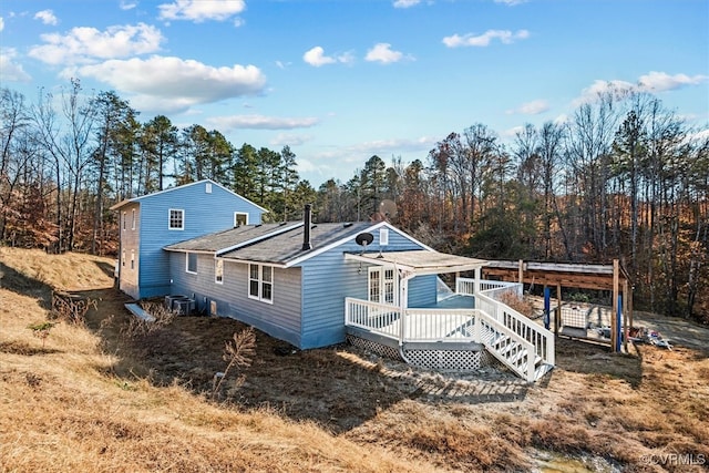 rear view of house featuring central AC unit and a deck