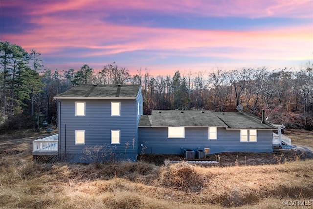 property exterior at dusk featuring cooling unit and a deck