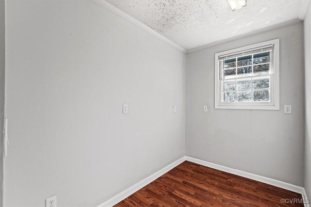 spare room featuring dark wood-style floors, crown molding, baseboards, and a textured ceiling