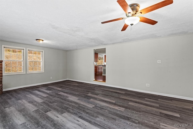 unfurnished living room with ceiling fan, a fireplace, dark wood-type flooring, and a textured ceiling