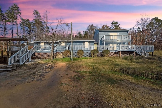 back of property at dusk with a deck and stairway