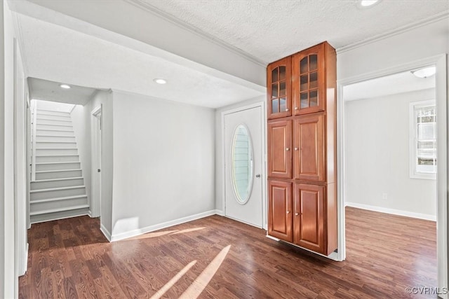 entryway with a textured ceiling, dark wood-style flooring, recessed lighting, and baseboards