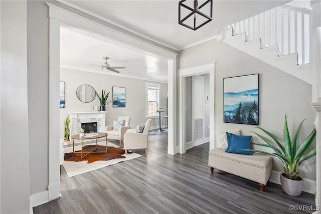 interior space featuring crown molding, ceiling fan, and dark wood-type flooring