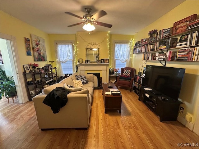 living room featuring a wealth of natural light, ceiling fan, and wood-type flooring