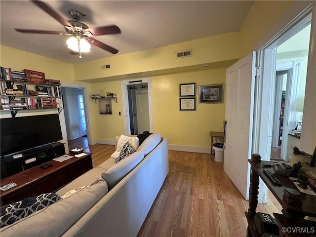 living room with ceiling fan and light hardwood / wood-style floors