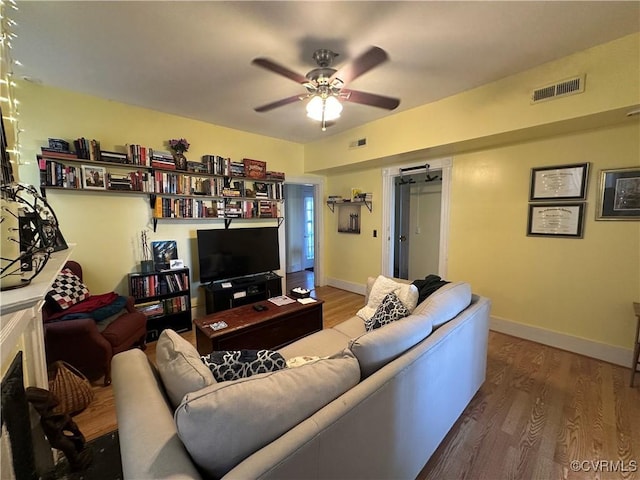 living room featuring ceiling fan and wood-type flooring