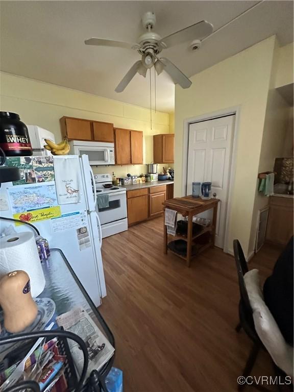 kitchen featuring dark hardwood / wood-style floors, ceiling fan, and white appliances