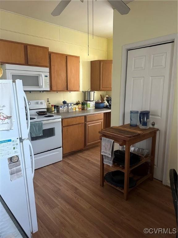 kitchen featuring dark hardwood / wood-style flooring, white appliances, and ceiling fan