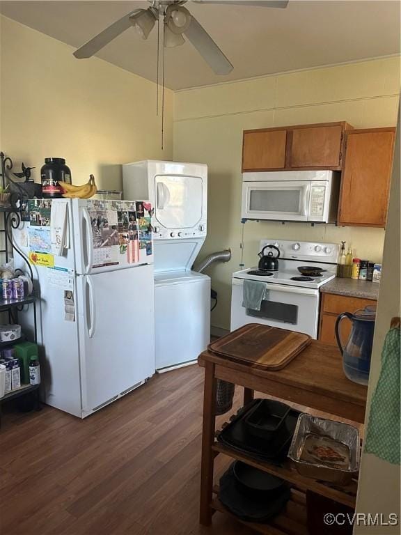 kitchen featuring stacked washer / dryer, ceiling fan, dark hardwood / wood-style floors, and white appliances