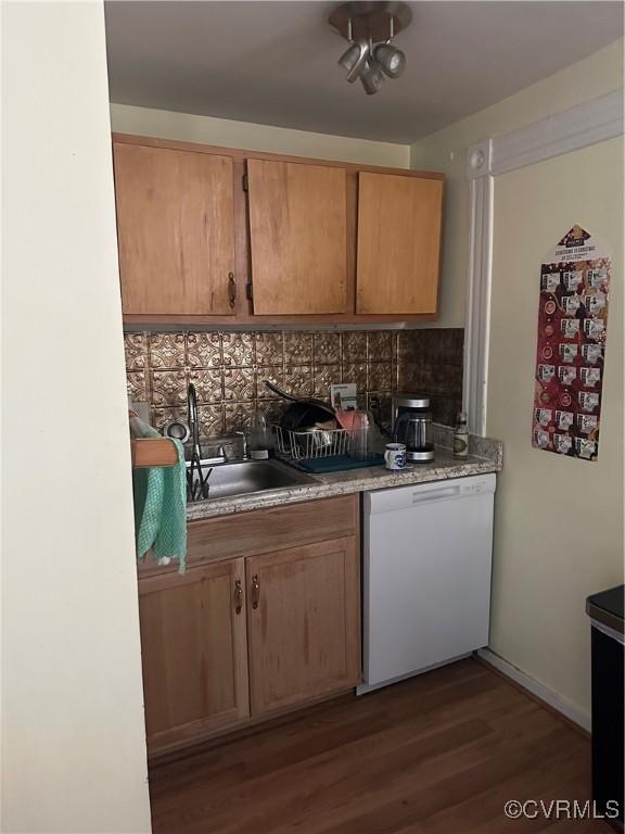 kitchen with backsplash, dishwasher, dark wood-type flooring, and sink