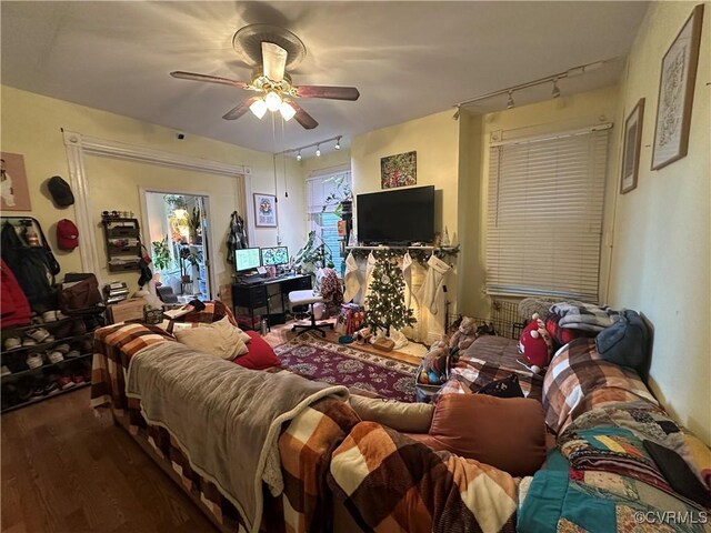 living room featuring rail lighting, hardwood / wood-style flooring, and ceiling fan