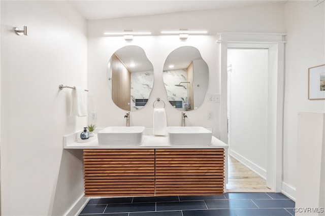 full bathroom featuring double vanity, tile patterned flooring, and a sink