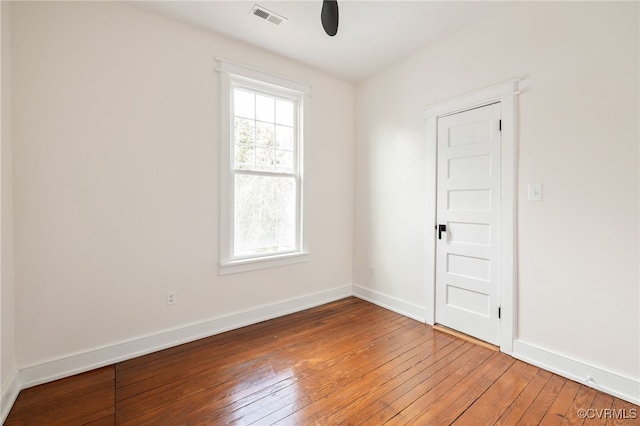 spare room featuring light wood finished floors, visible vents, and baseboards