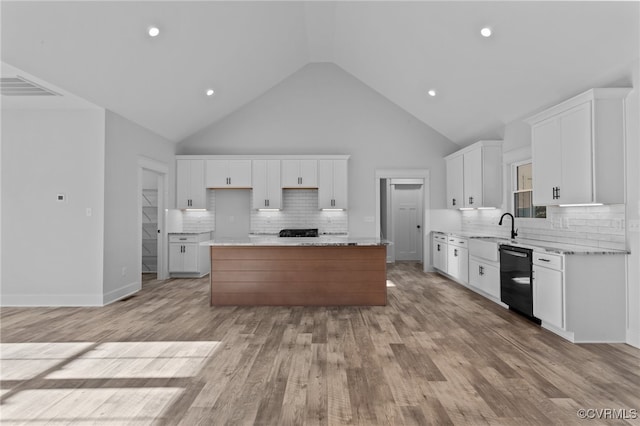 kitchen featuring a kitchen island, high vaulted ceiling, light hardwood / wood-style flooring, dishwasher, and white cabinetry