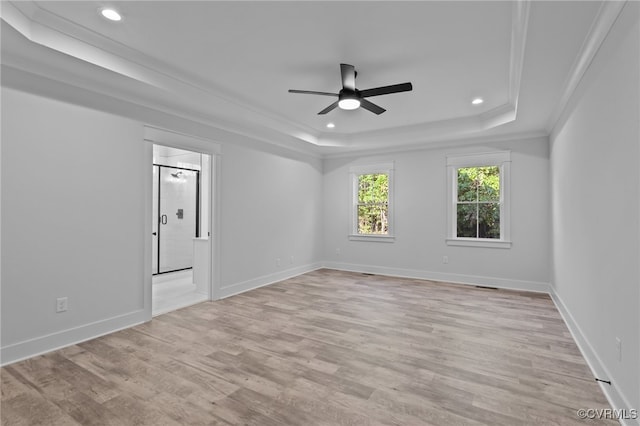 unfurnished room featuring ceiling fan, light hardwood / wood-style floors, crown molding, and a tray ceiling