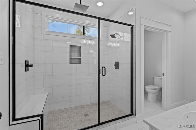 bathroom featuring vanity, toilet, and a shower with shower door